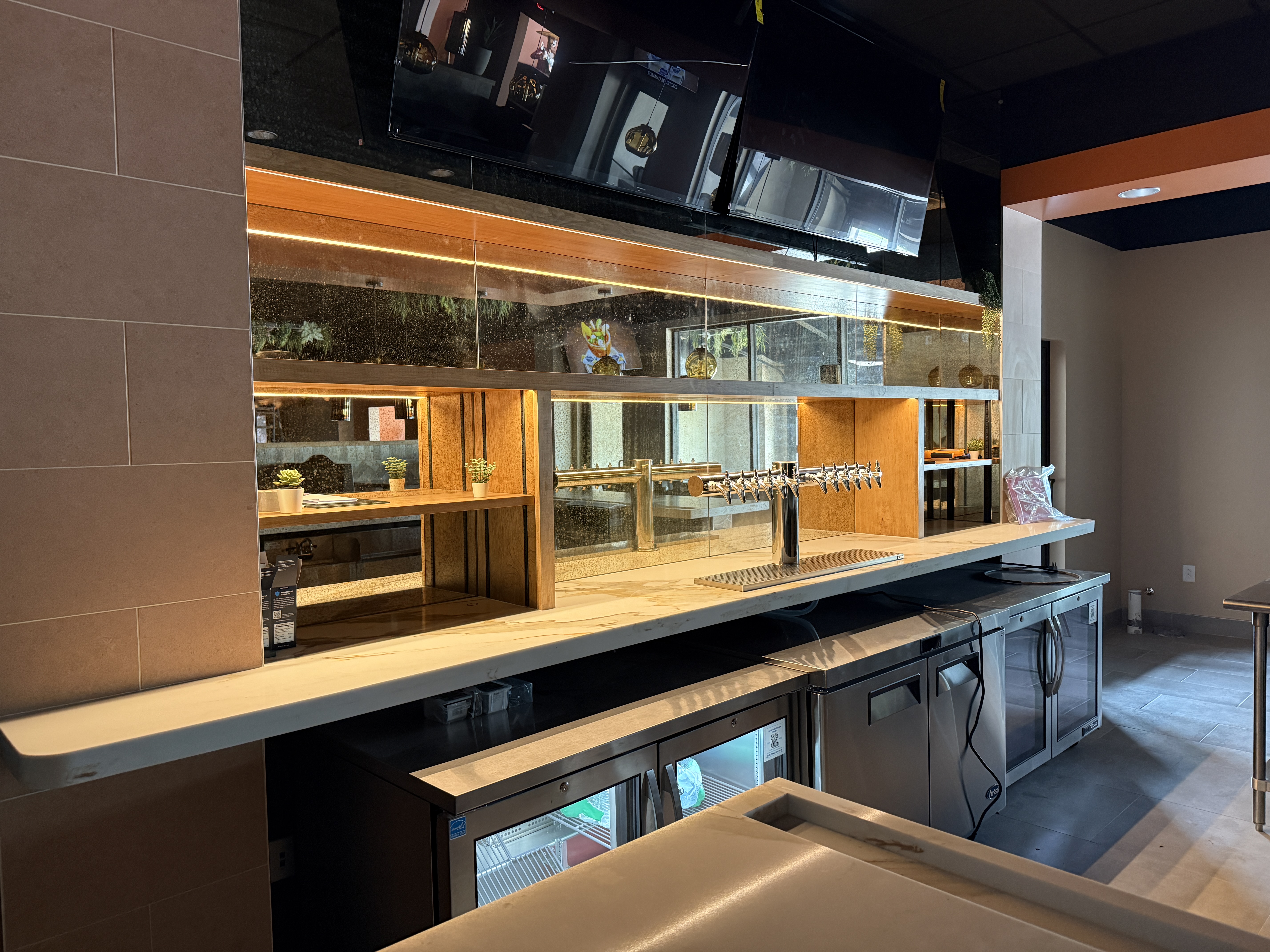 Bar with wood shelving, a marble counter, and a steel tap system