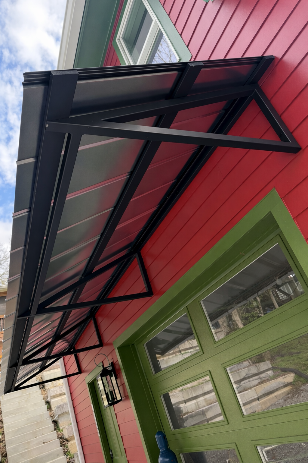 Black steel awning mounted above an entry