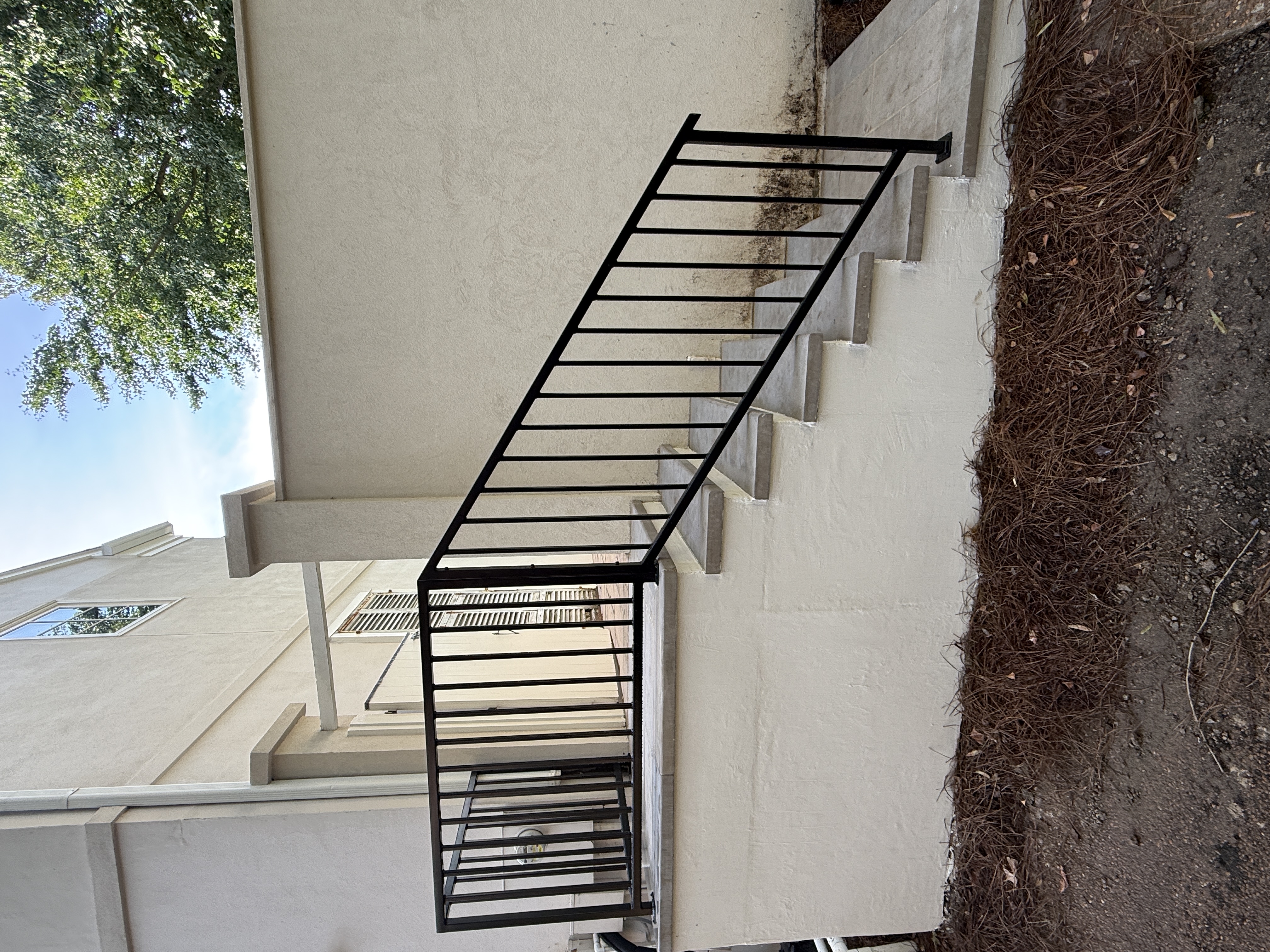Black steel railing on exterior concrete steps