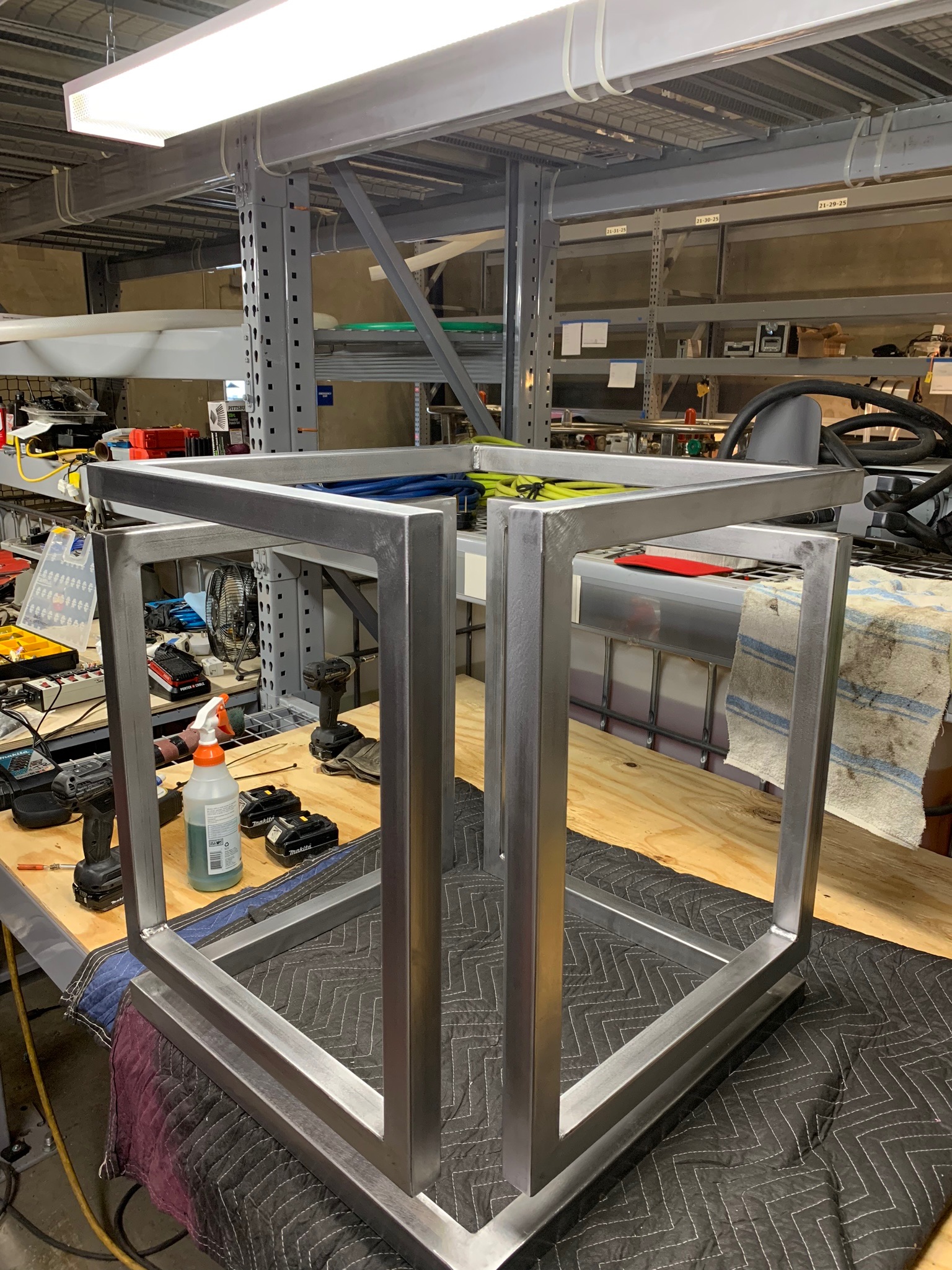A welded steel frame on the workbench in the Arc + Timber shop