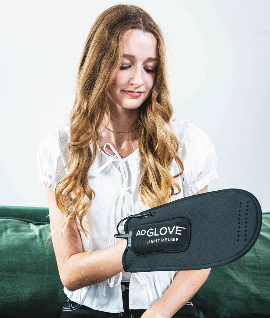 Woman holding the AO Glove light therapy device