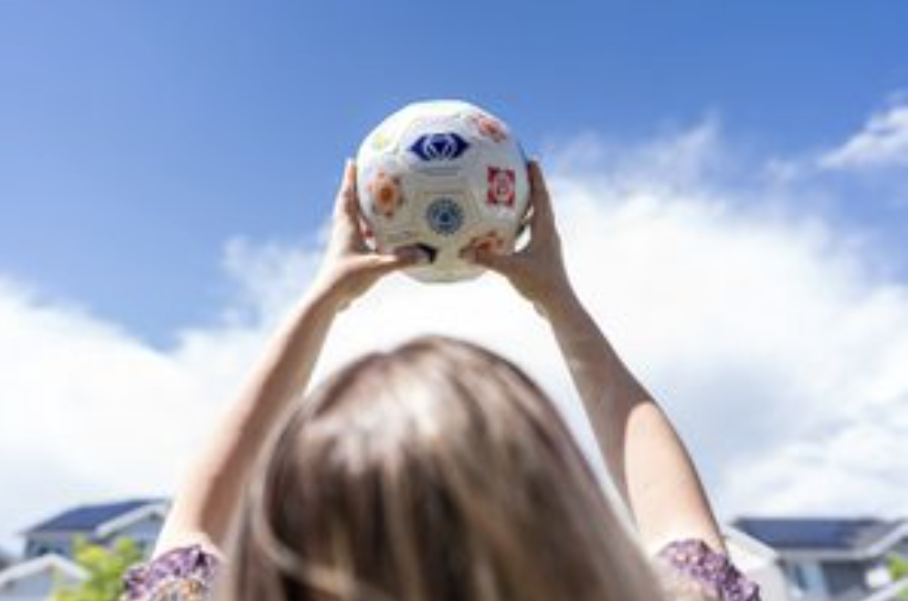 Holding a colorful Cognomovement ball up to a bright blue sky