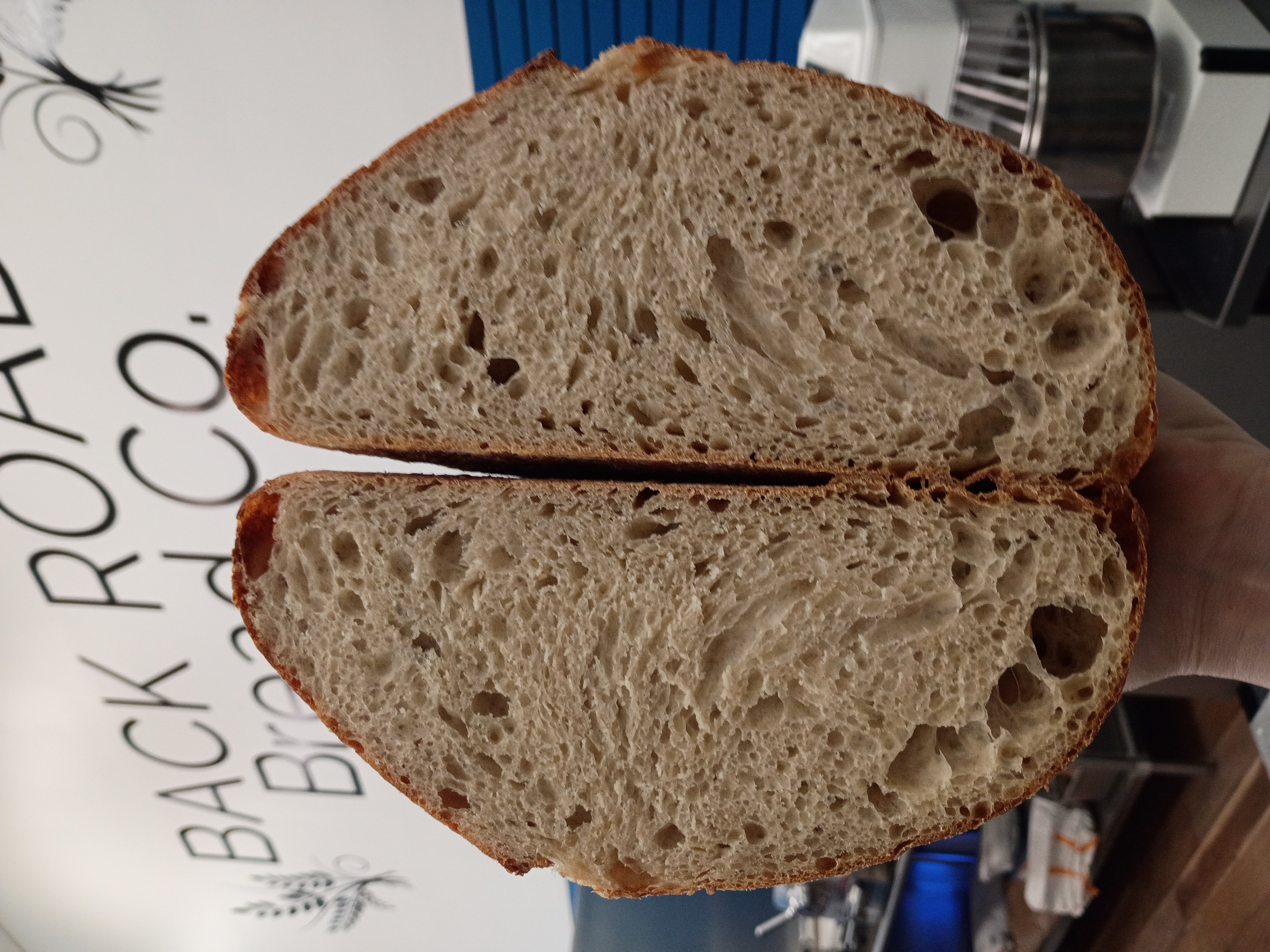A sliced loaf of house sourdough showing an airy, open crumb