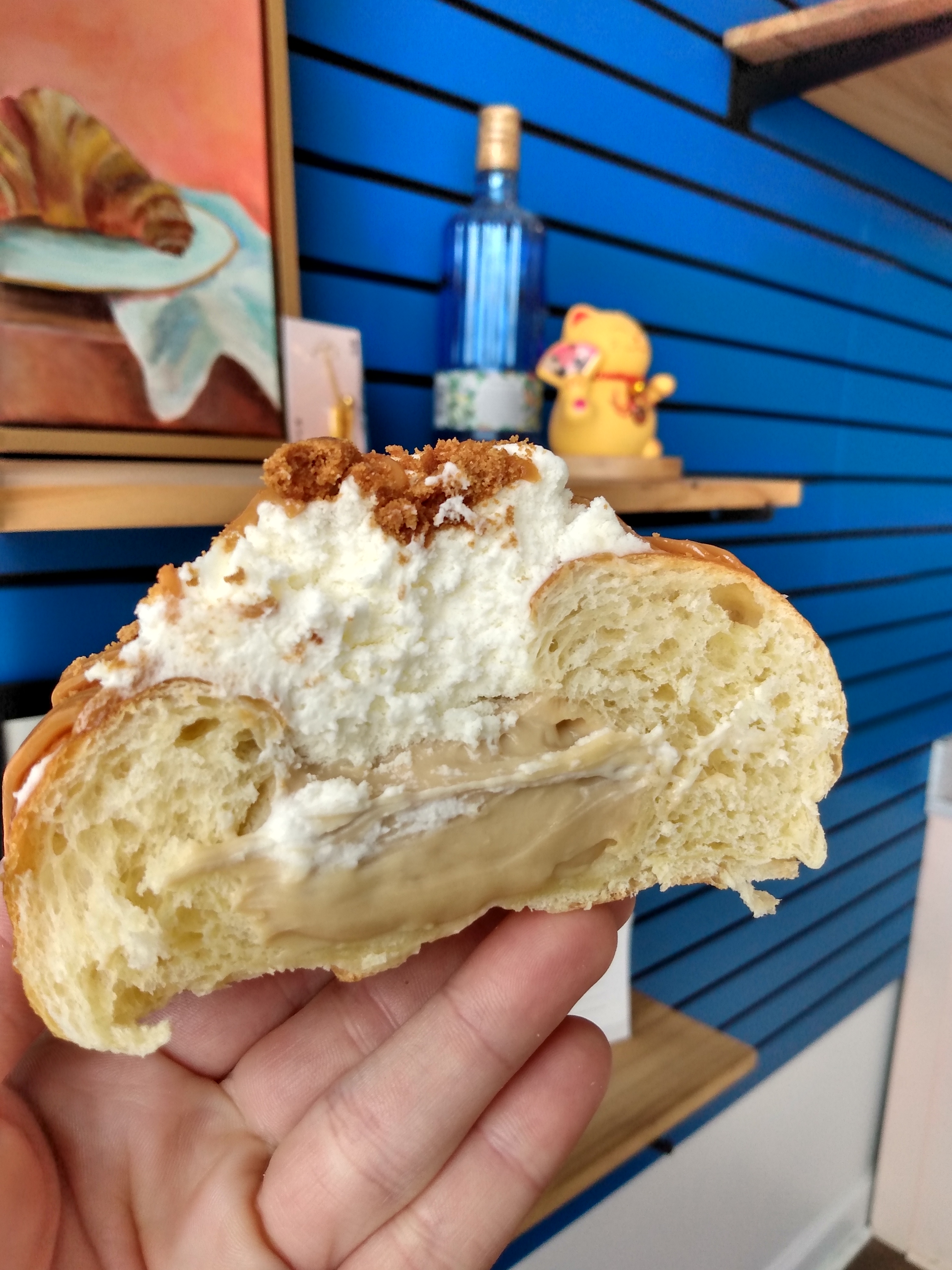 A banoffee brioche filled with custard and topped with whipped cream and speculoos crumbs